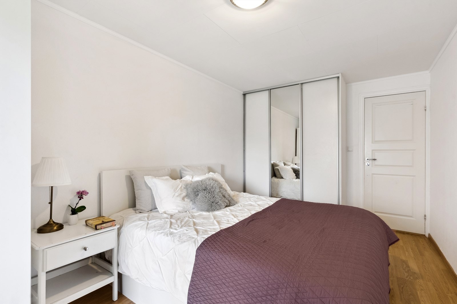 Det største soverommet har god plass til dobbeltseng og nattbord i tillegg til innebygd skyvedørsgarderobe med speilflater og frittstående garderobe Galleribilde