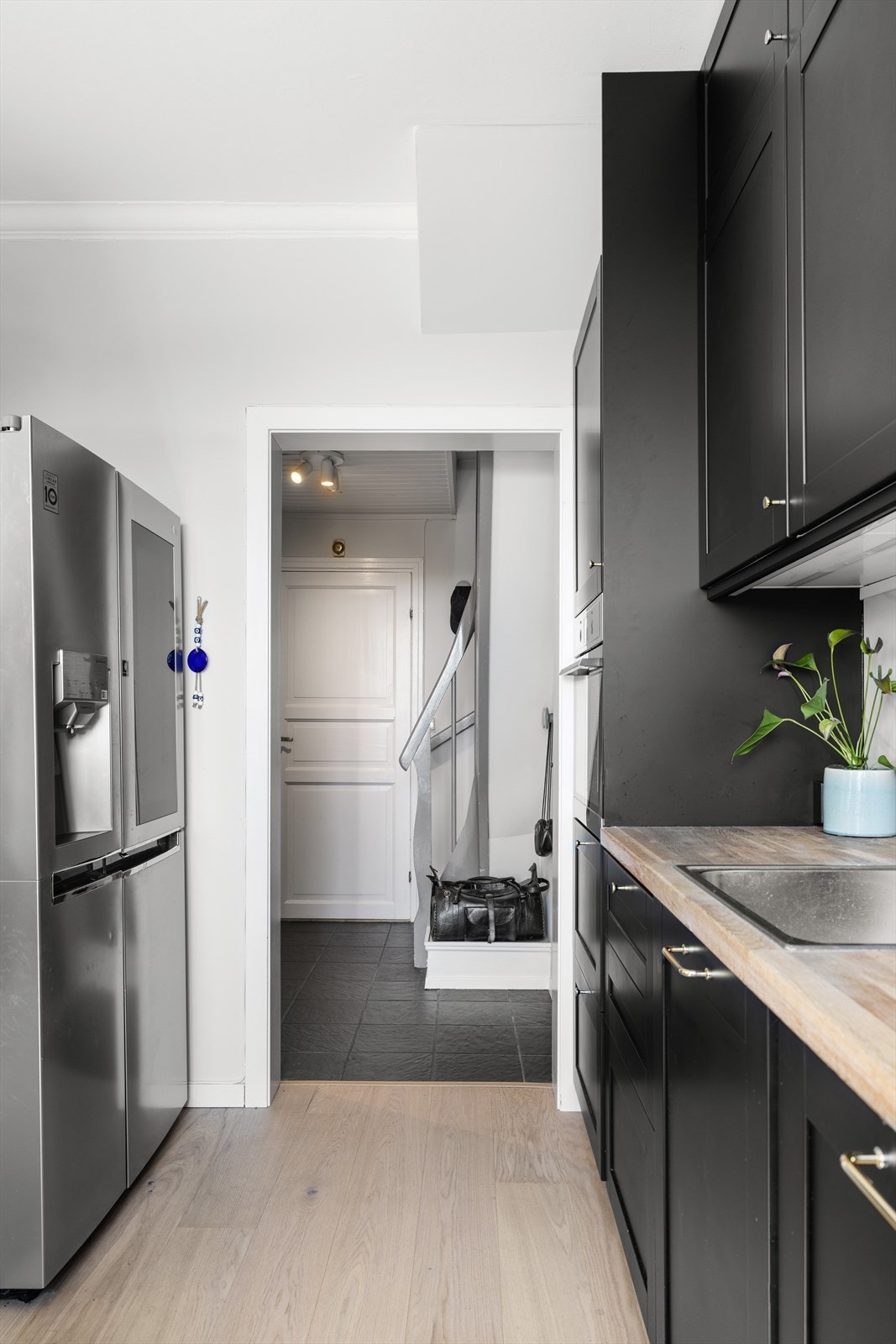 Integrerte hvitevarer bestående av stekeovn i høyskap, oppvaskmaskin under benk og nedfelt platetopp, samt ventilator i overskap med kullfilter. Frittstående side by side kjøleskap med frysedel er praktisk plassert i eget hjørne på kjøkkenet. Galleribilde