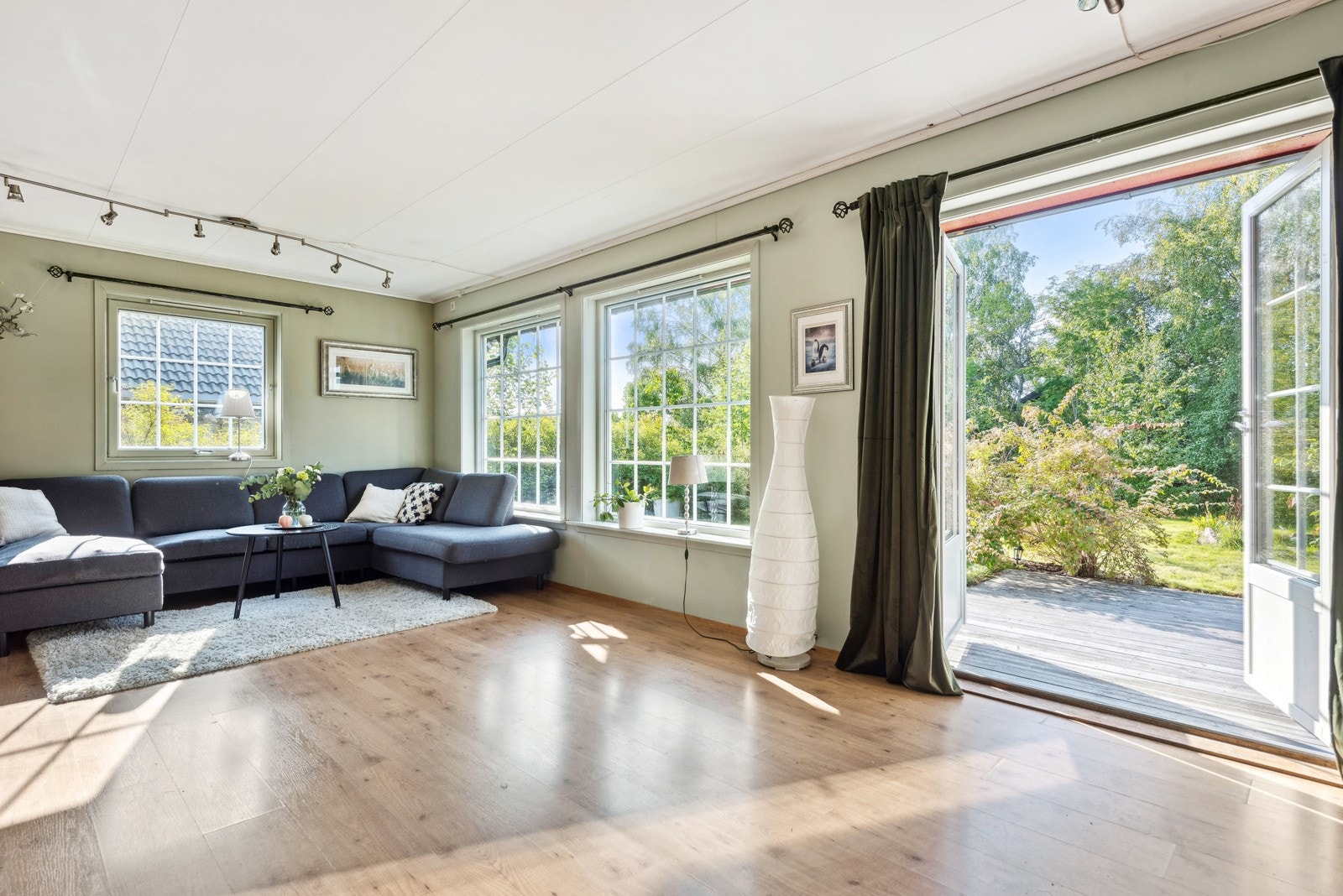 Fra stuen er det utgang gjennom en tofløyet terrassedør til terrassen og hagen. Galleribilde