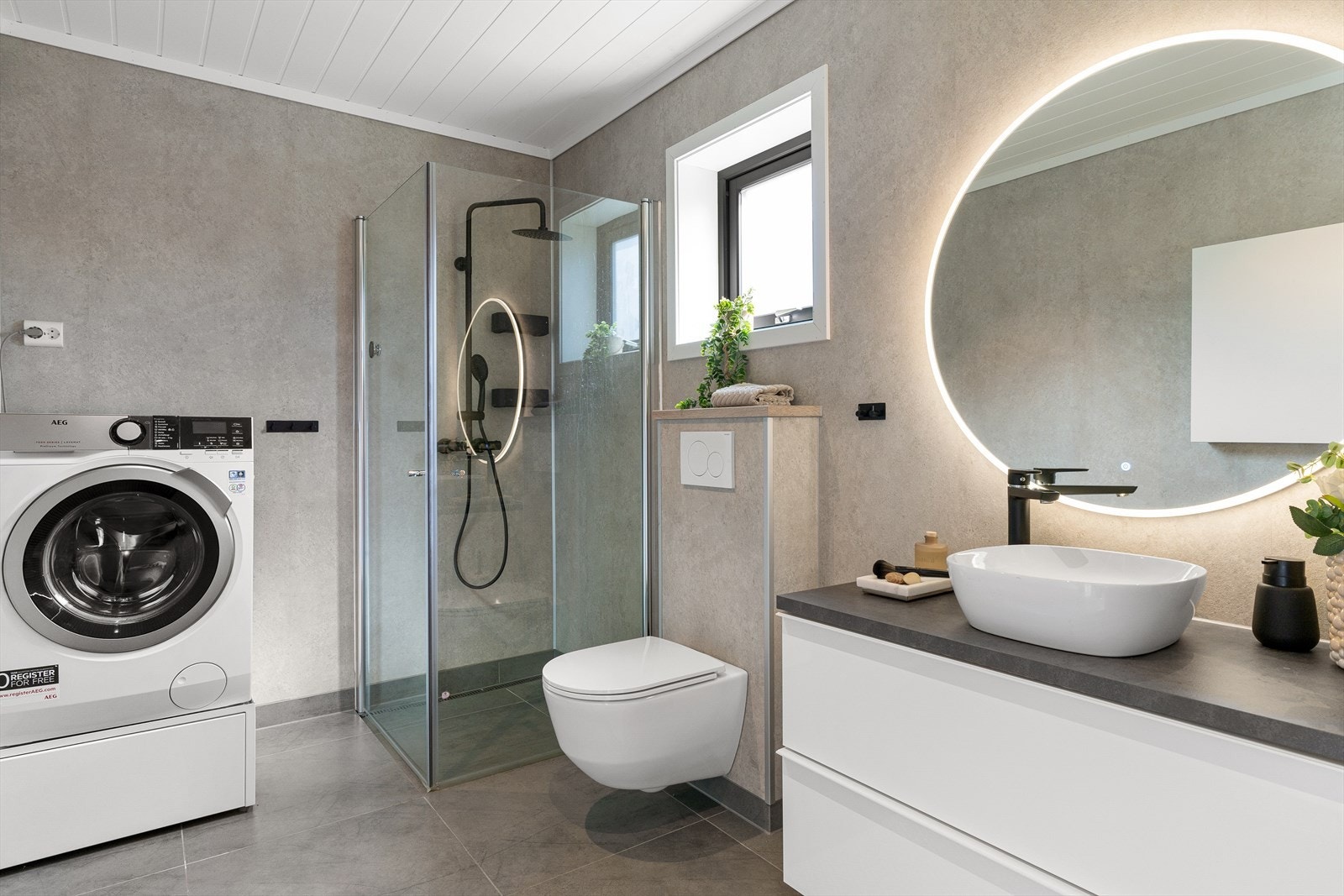 Badet har flislagt gulv og baderomsplater på vegger. Galleribilde