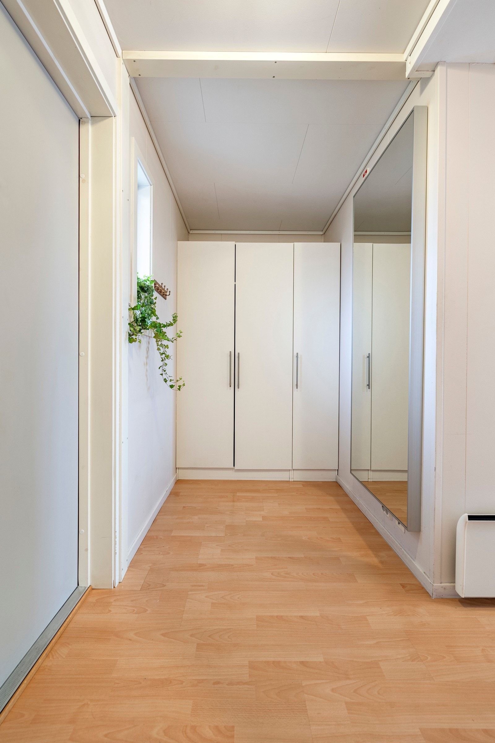 Arealeffektiv og lys leilighet med gjennomgående planløsning. Leiligheten har adkomst via en hyggelig svalgang og inngang til en entré med laminatgulv, vindu og lyse overflater. Entreen er innredet med et tredørs garderobeskap. Galleribilde