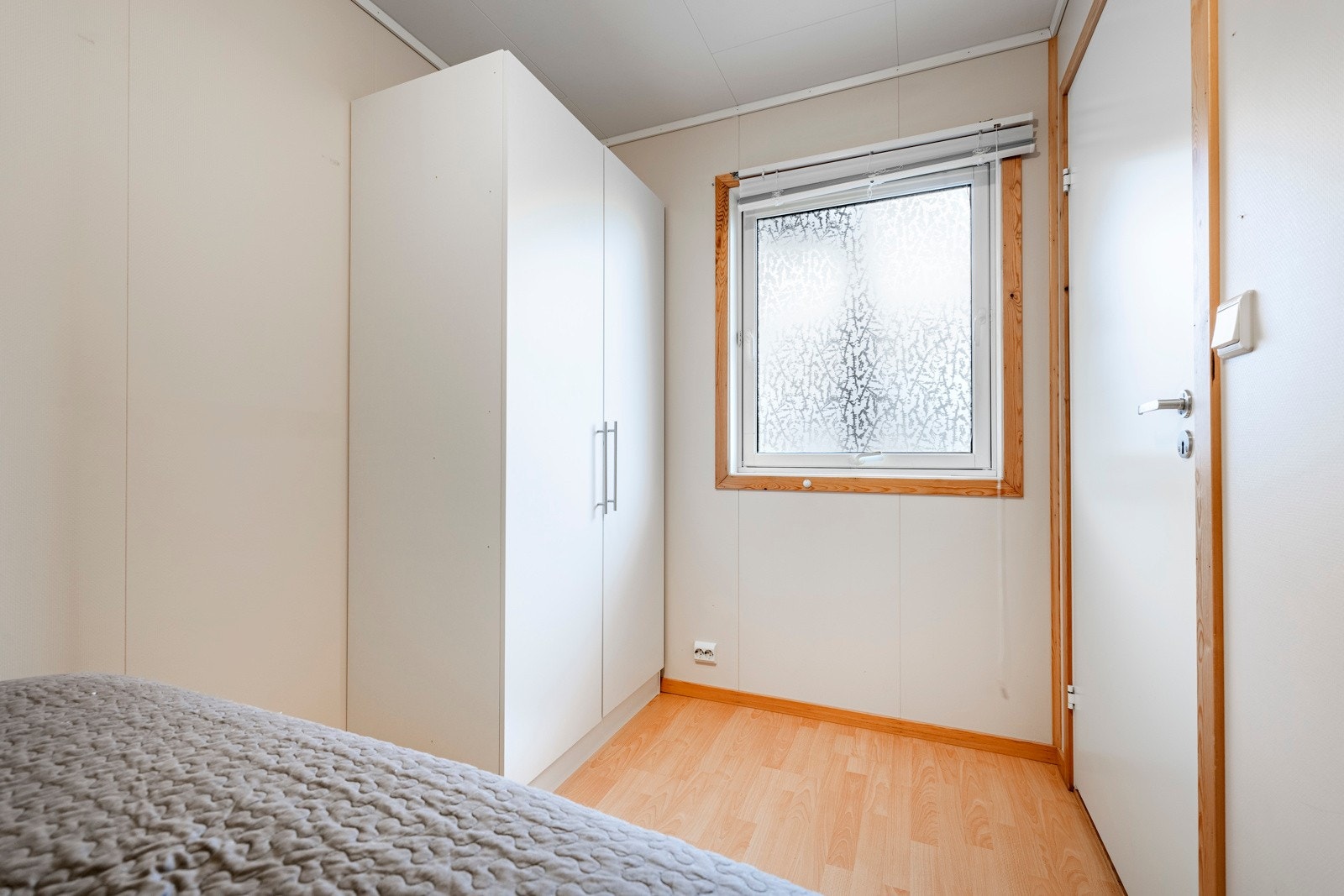 Soverommet har østvendt vindu mot svalgangen, laminat på gulv, lysmalte vegger og noen trehvite lister. Rommet er innredet med garderobeskap og har plass til en bred seng. Galleribilde