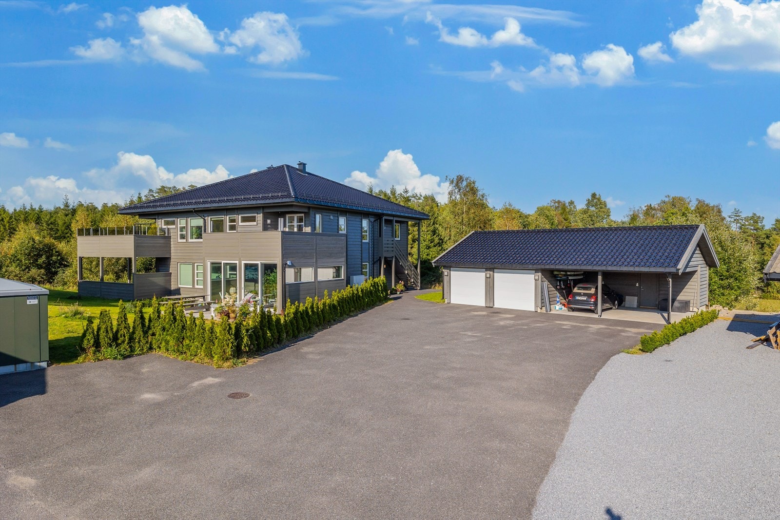 Praktisk gårdsplass med parkering i carport samt bod i bakkant. Galleribilde
