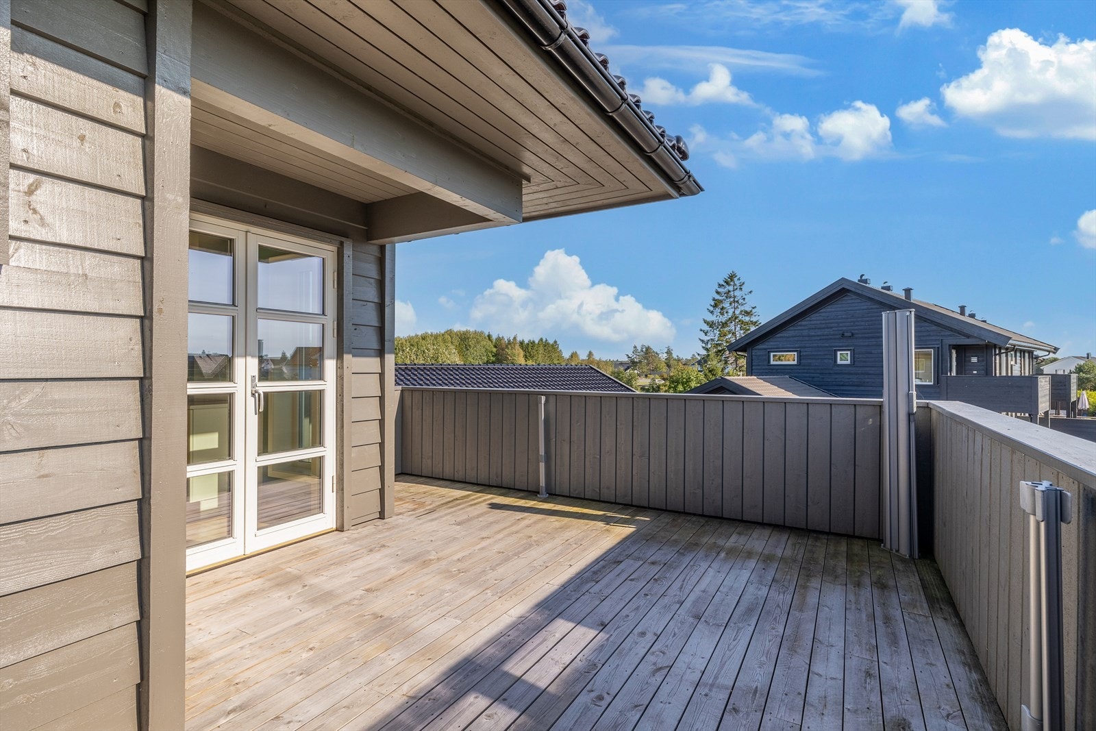 Stor terrasse med glass dører ut for å nyte et måltid i det fri. Galleribilde