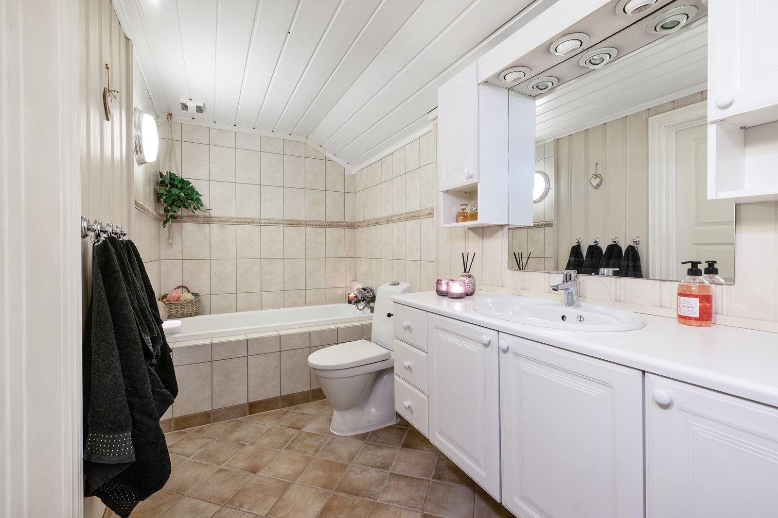 Badet har også flislagt badekar og toalett. Galleribilde