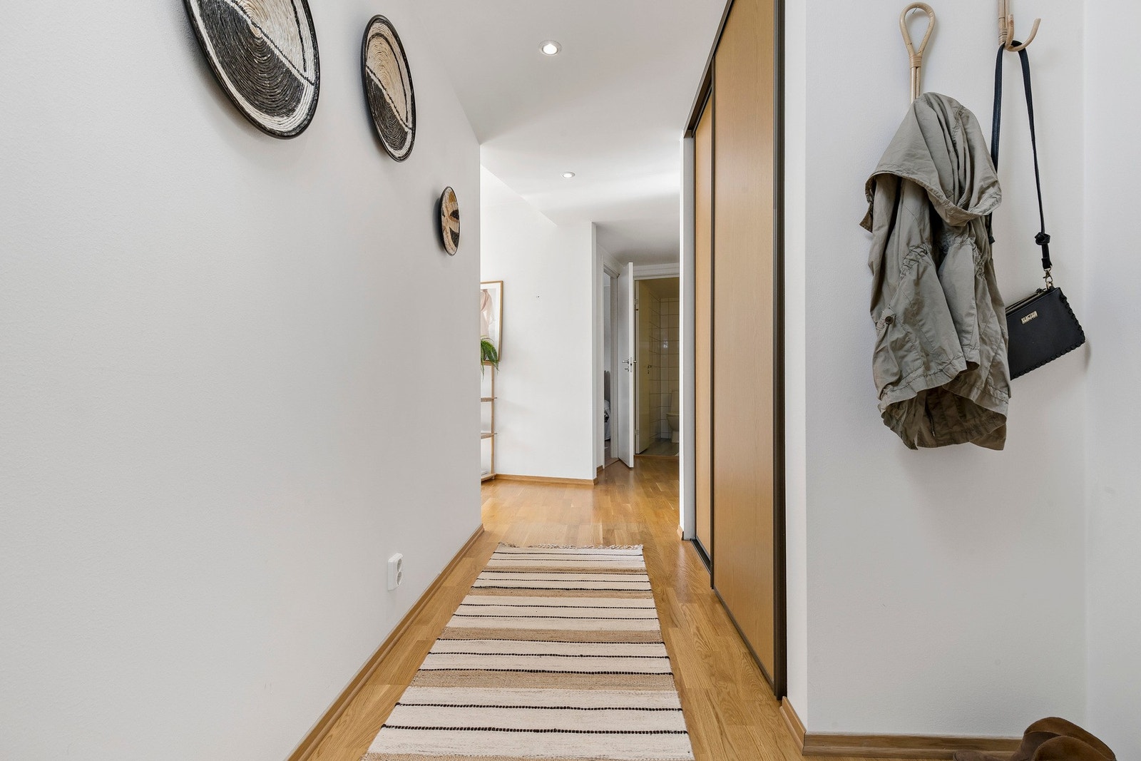 Romslig entré med skyvedørsgarderobe. Galleribilde