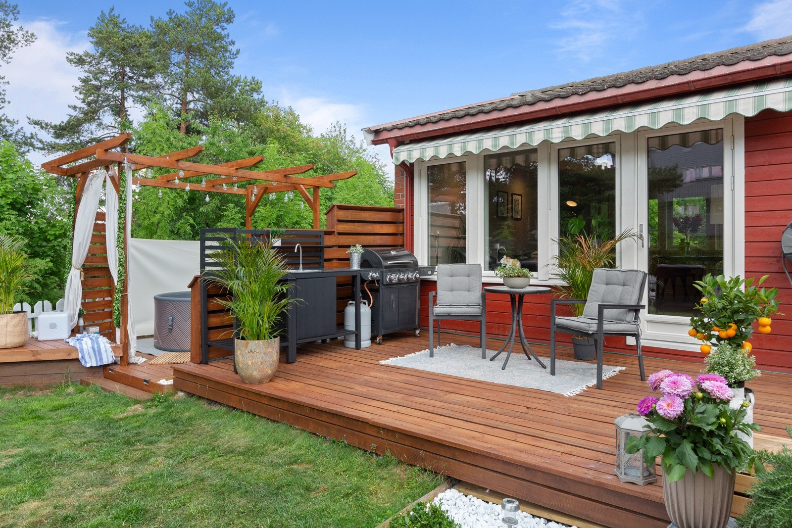 Den nærmeste terrassen har direkte utgang fra stuen og har markisse som beskytter mot sol og regn Galleribilde