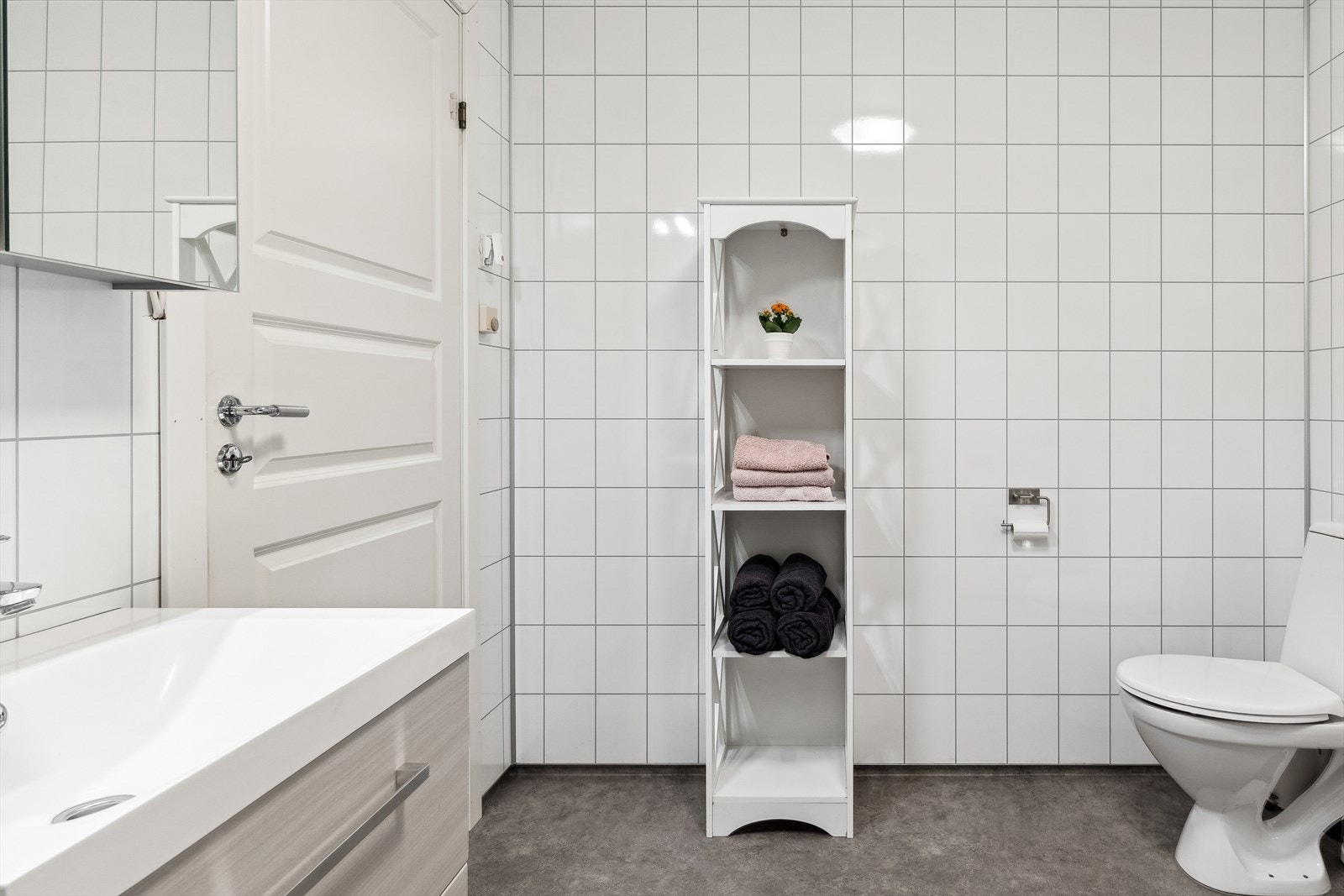 Pent bad med belegg på gulv og plater på vegg. Galleribilde