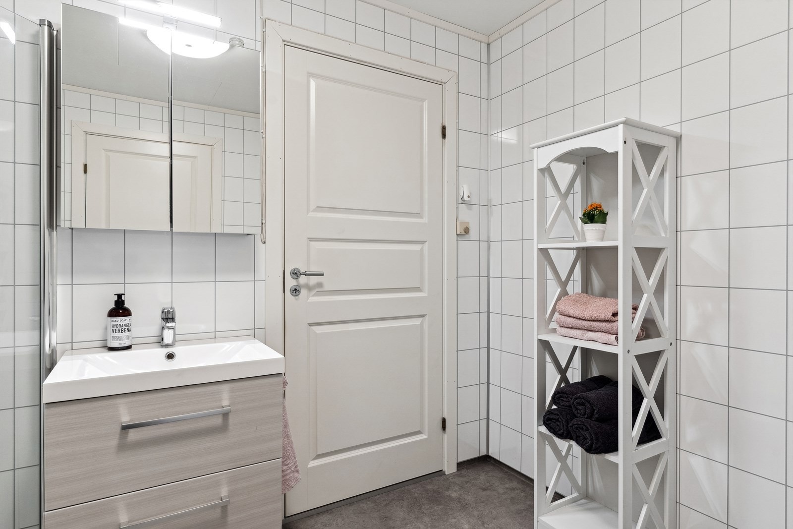 Badet er innredet med dusjhjørne, toalett og baderomsinnredning med heldekkende servant. I tillegg er det speilskap over servant. Galleribilde