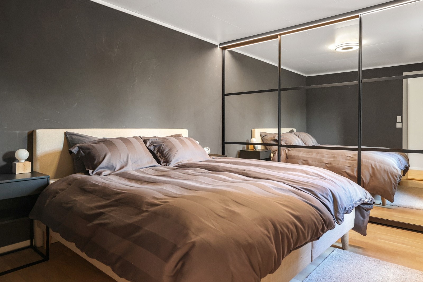 For oppbevaring har rommet en skyvedørsgarderobe med speil Galleribilde