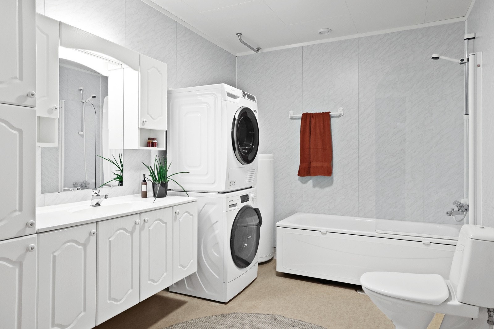 Badet er innredet med en hvit innredning med speil og meget god skapplass Galleribilde