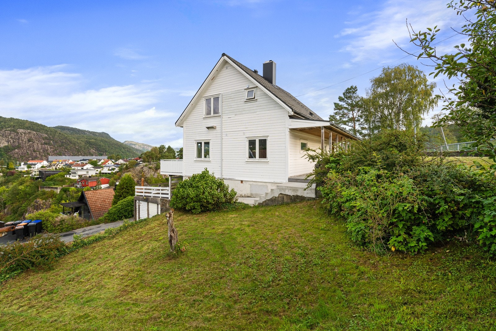 Stor hage med plen rundt store dele av boligen. Galleribilde
