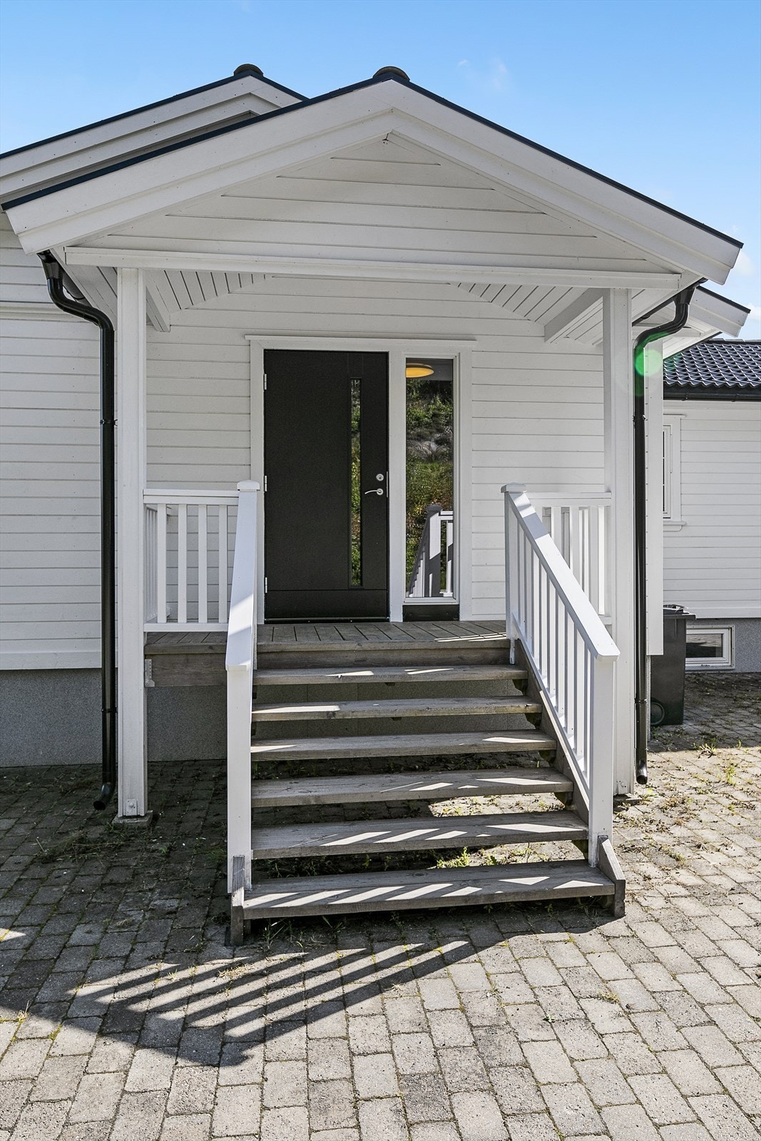 Brosteinlagt i tun ved inngangsparti. Galleribilde
