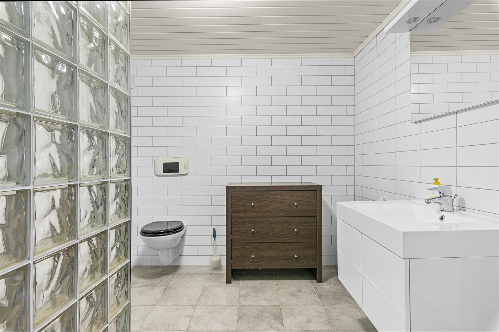 Badet i underetasjen inneholder vegghengt wc, dusjhjørne og håndvask med skuffer. Opplegg for vaskemaskin. Galleribilde