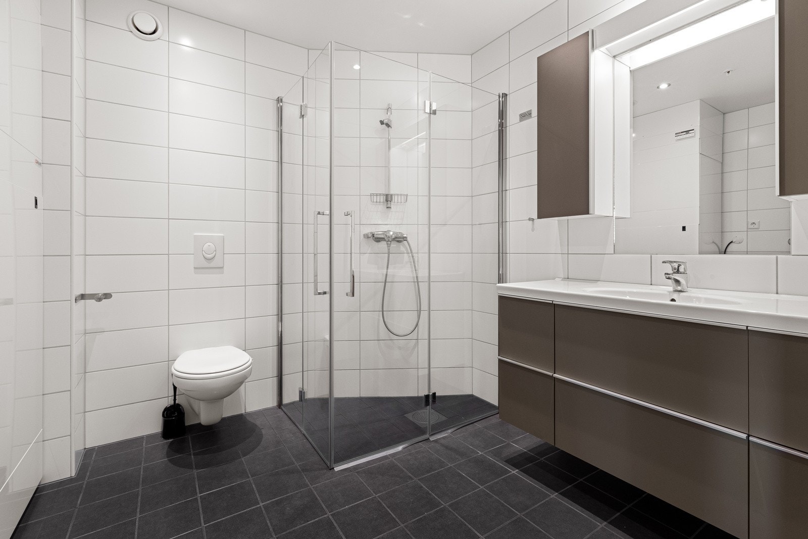 Badet har foldedører i dusjhjørnet og stor baderomsinnredning Galleribilde