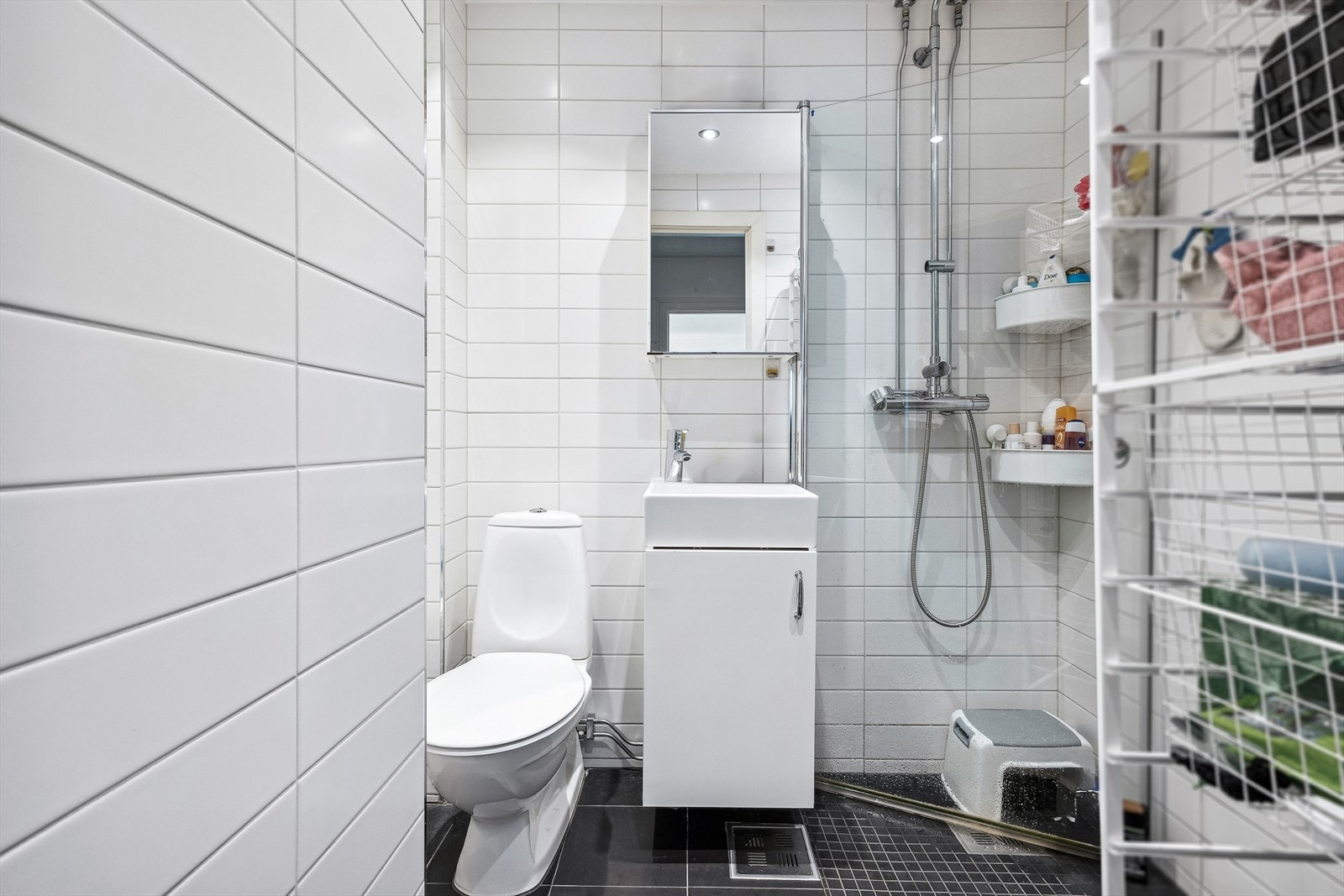 Badet er utstyrt med gulvstående wc og servantinnredning med under- og overskap. Galleribilde