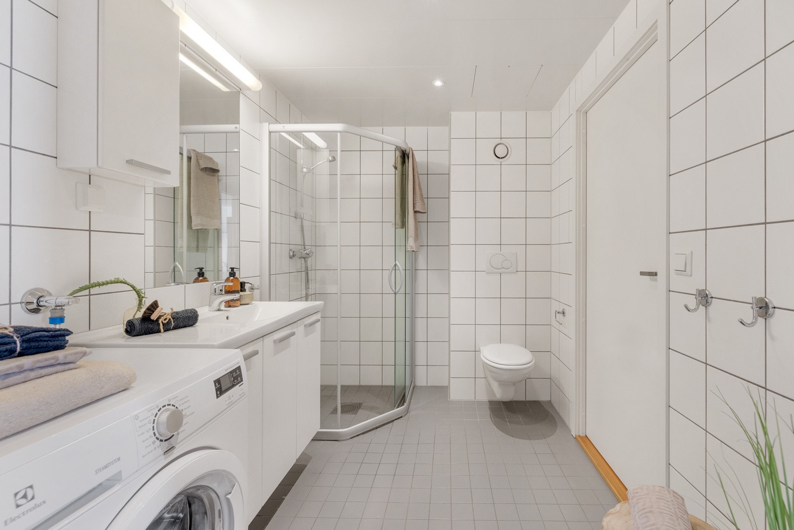 Prefabrikert baderom fra byggeår med flislagt gulv med varme, flislagte vegger og med downlights i himlig. Galleribilde