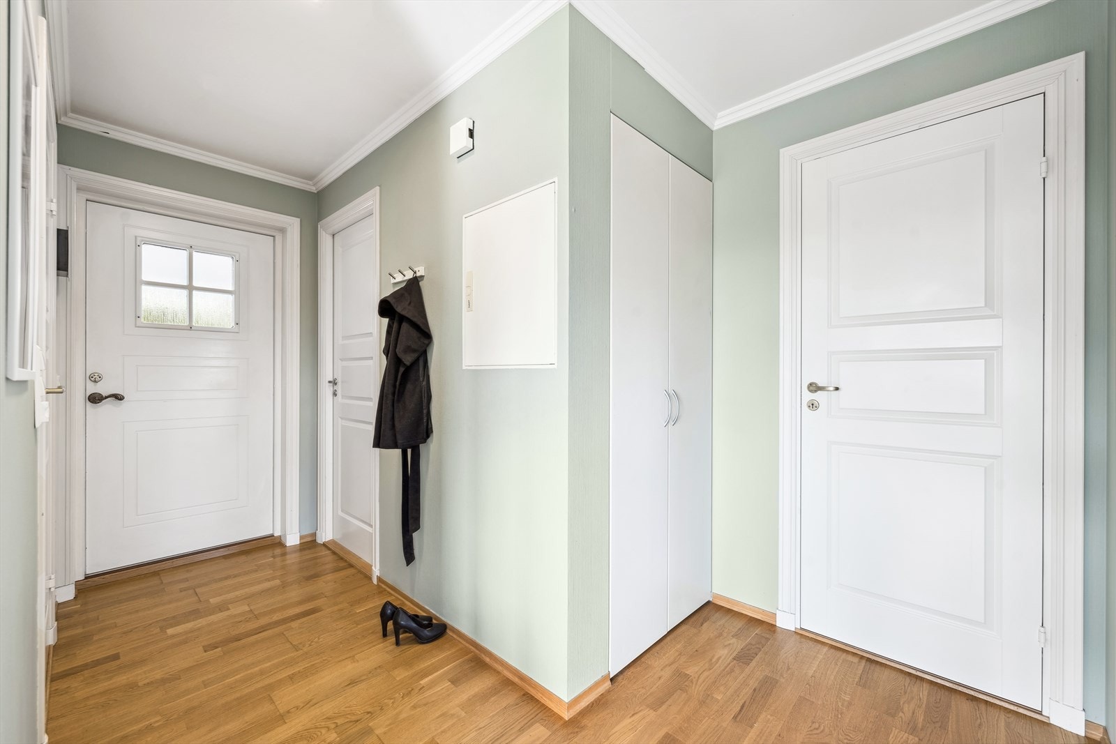 Velkommen inn! Du kommer inn i entrèen og møtes av pen parkett på gulv og malte vegger. Her er det et praktisk innebygd skap med god plass til å henge av seg ytterklær. Galleribilde