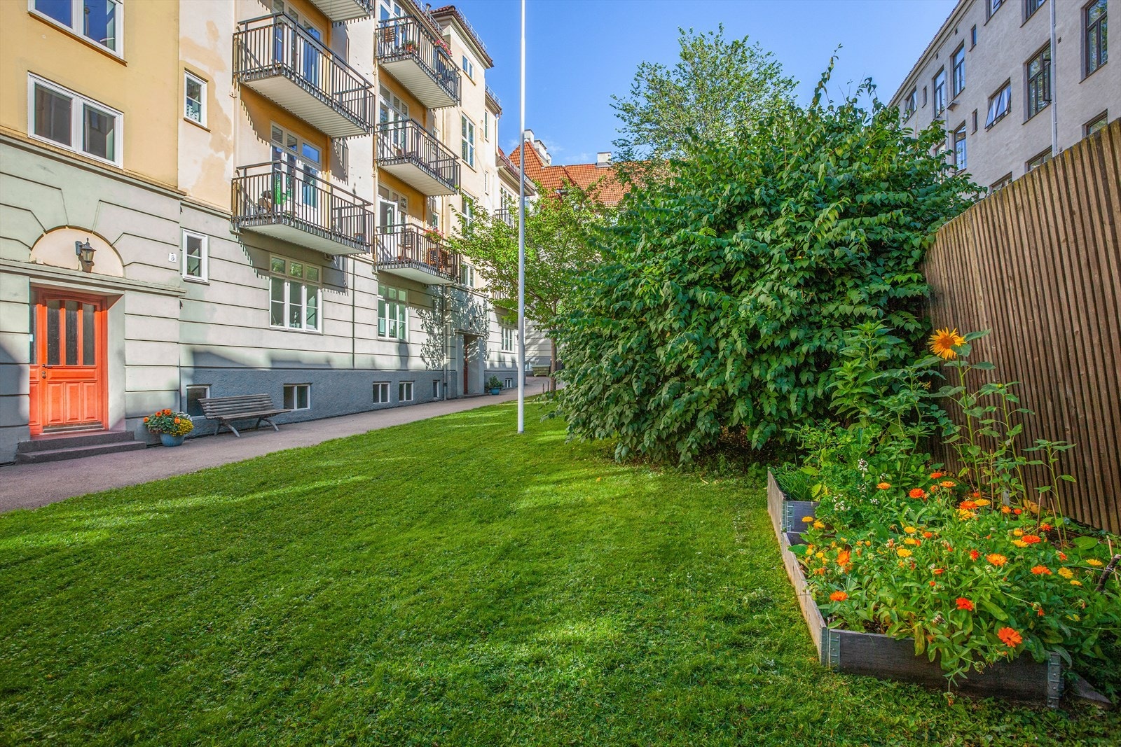Pent opparbeidet fellesareal med asfalterte adkomstveier/plasser, steinbelagte arealer, gressplen, beplantning, trær, sittegrupper m.m. Galleribilde