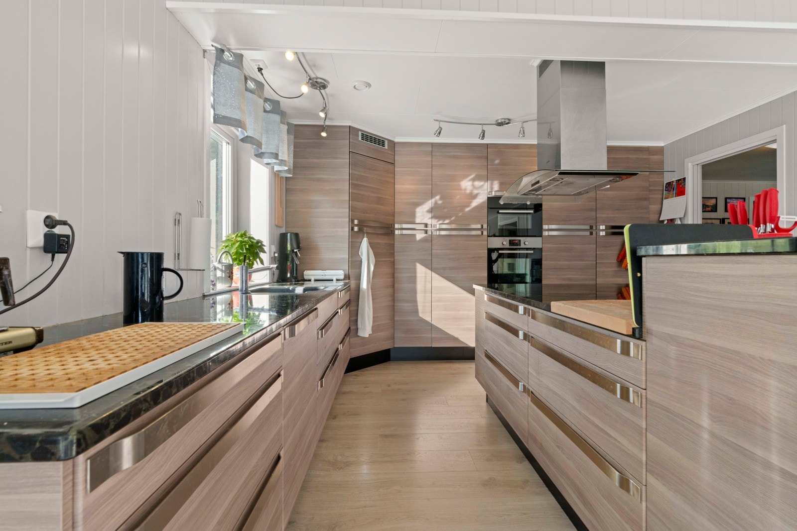 Kjøkkenet har en romslig innredning med mye skap- og benkeplass Galleribilde