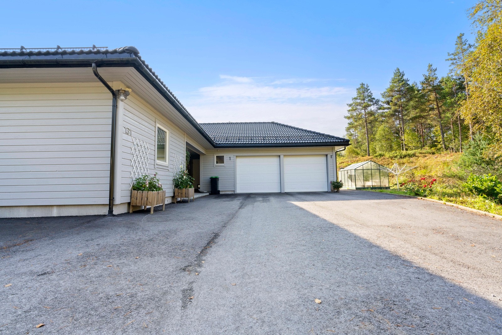 Asfaltert tunplass ved inngangspartiet Galleribilde