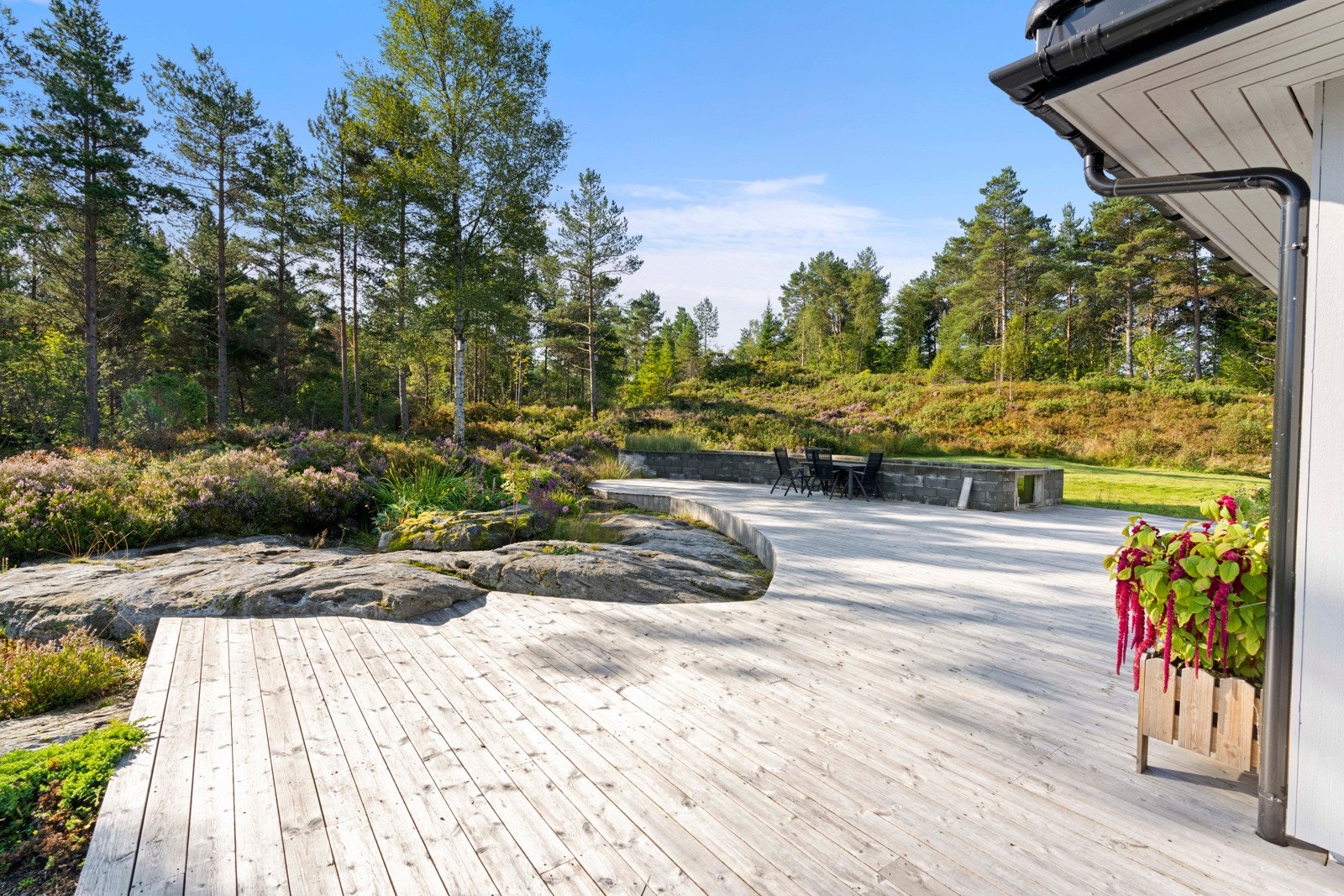 Mot sør er det fint opparbeida hage med terrasse, fiskedam og grøntareal Galleribilde