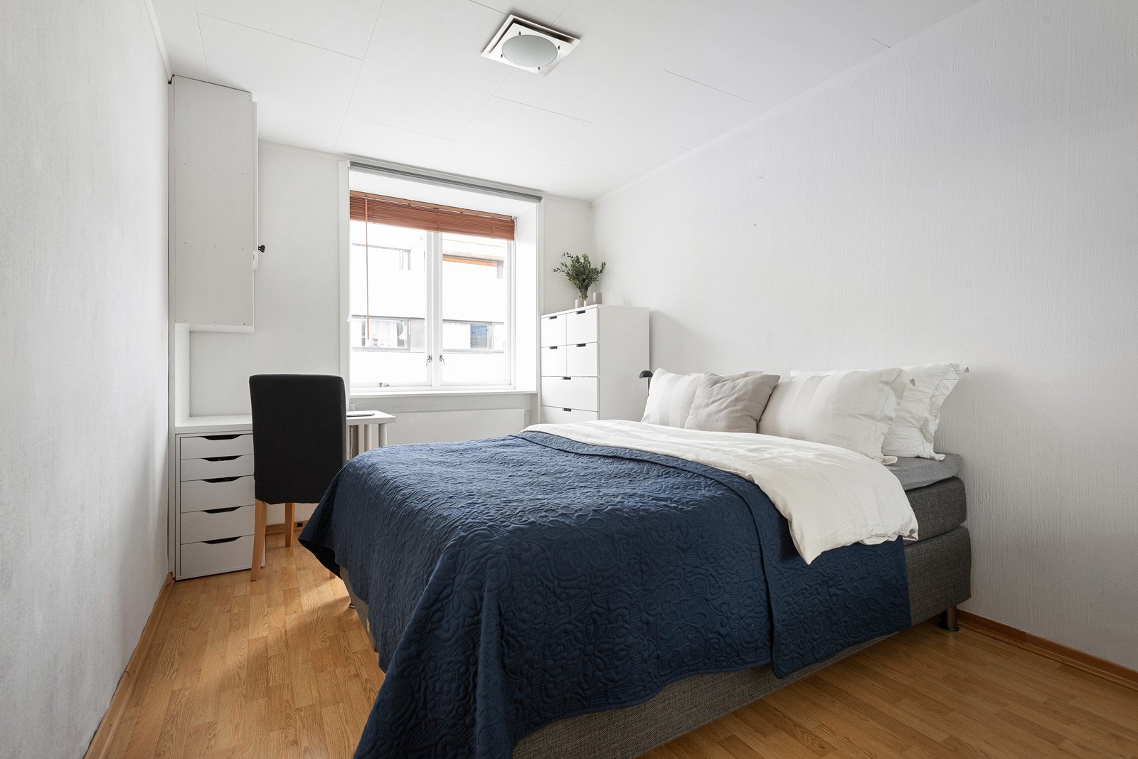 Stort soverom med plass til dobbeltseng, nattbord på begge sider, kontorpult og skap Galleribilde