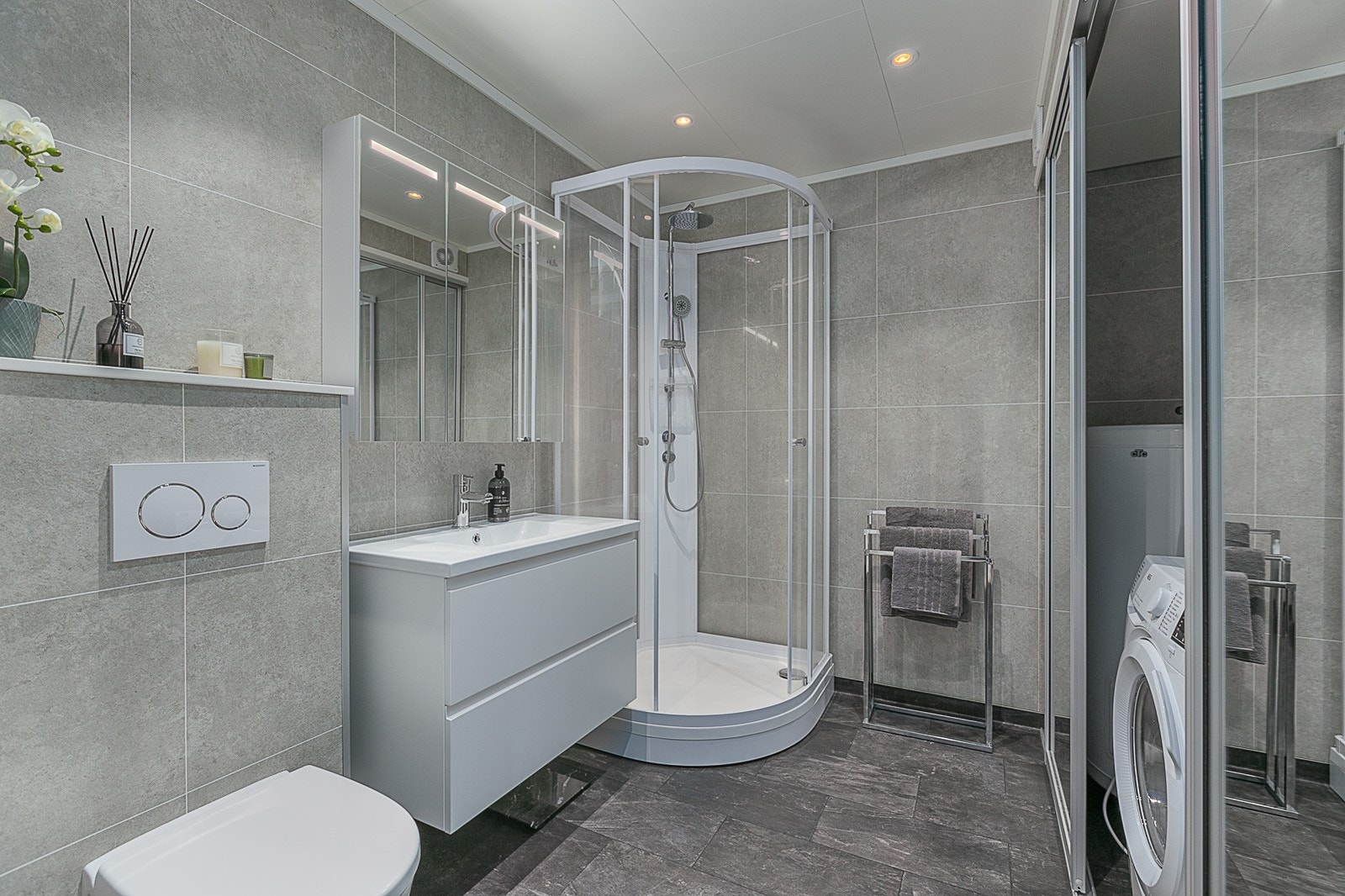 Badet har praktisk løsning med vaskemaskin bak skyvedører. Galleribilde