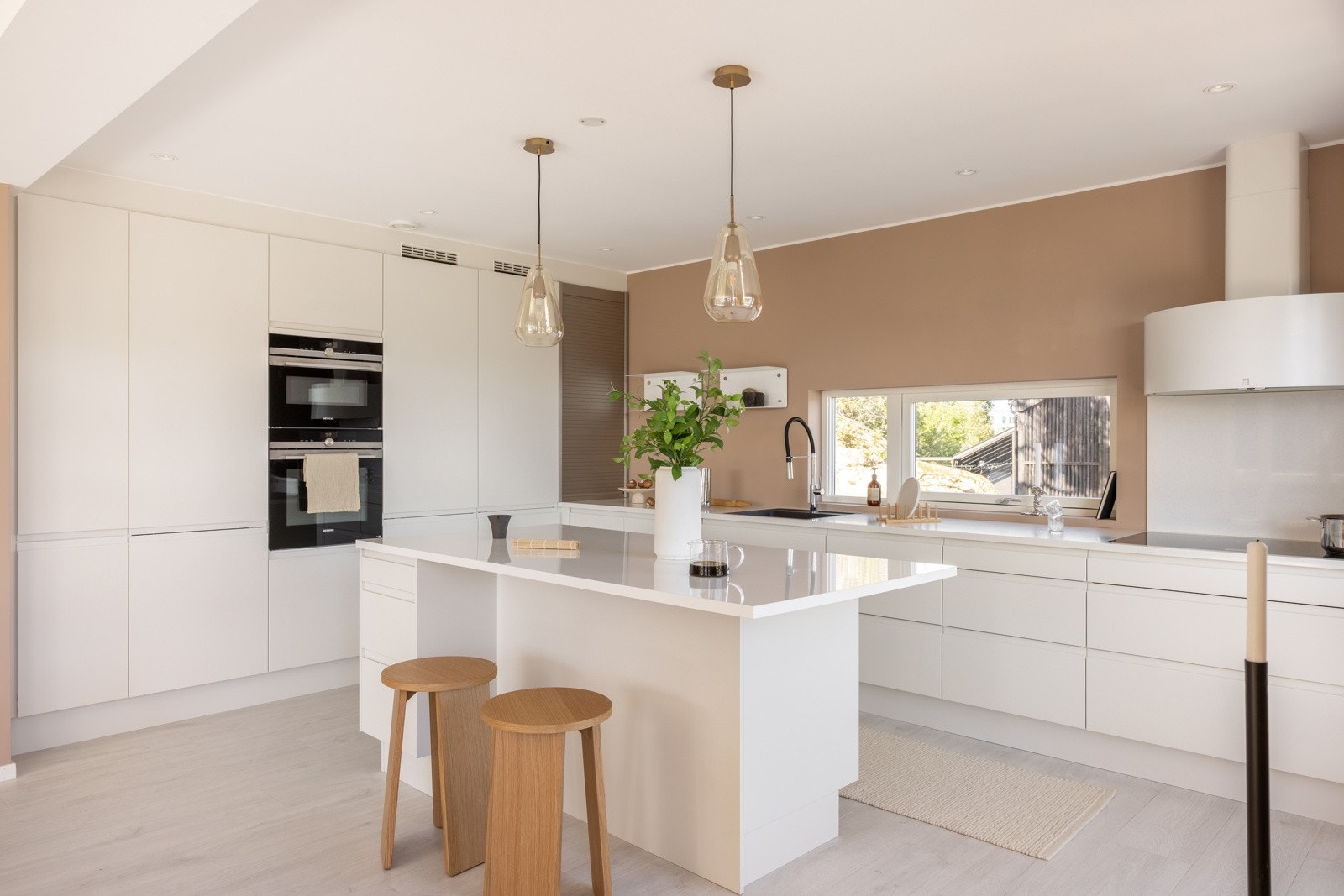 Flott og stilrent kjøkken med praktisk utforming og sosial kjøkkenøy med barløsning. Galleribilde