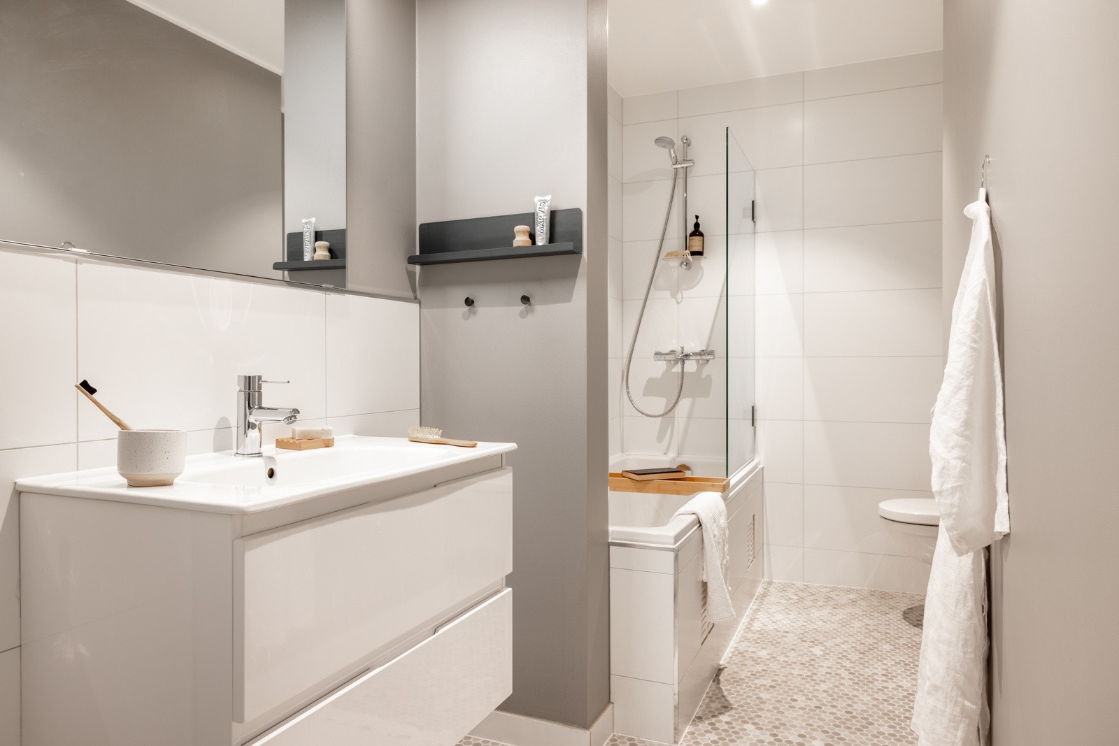 Etasjens bad måles til 5 kvm og har en gjennomført sammensetning av ulike materialer og farger. Varmekabler i gulv. Galleribilde