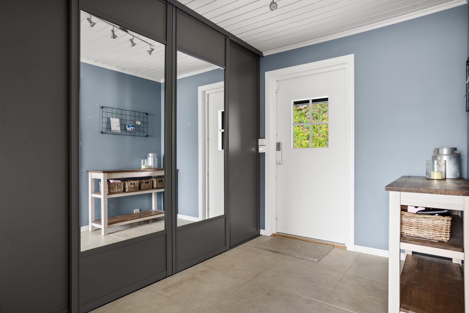 Romslig entrè med stor garderobe. Fliser og varmekabler i gulv.