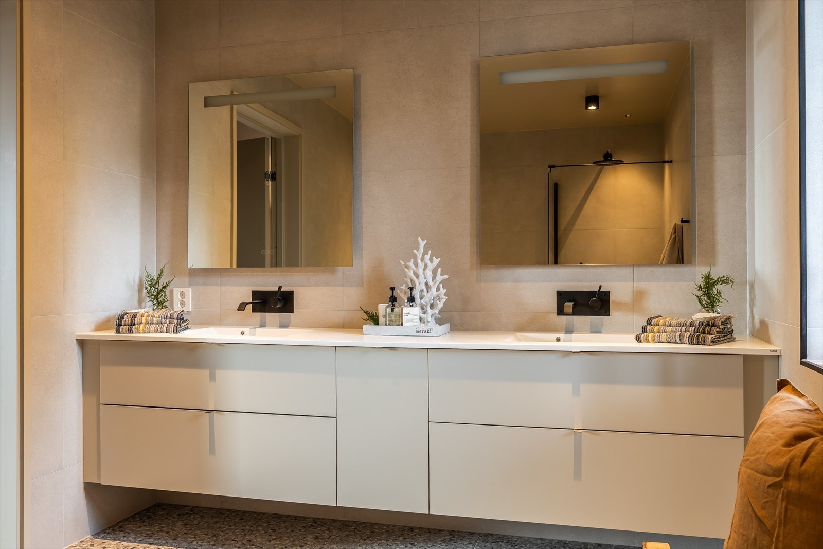 Romslig og lekkert baderom bestående av dobbel servantskap med underskuffer, dushjørne med glass. vegghengt toalett og et stort badekar. Galleribilde