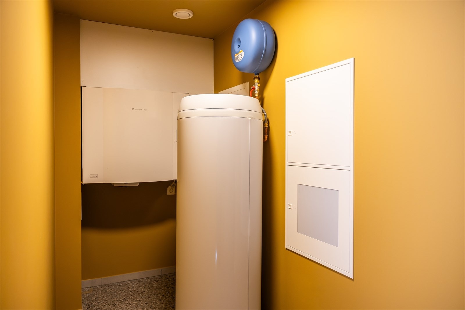 Teknisk rom ligger vegg i vegg med vaskerommet og inneholder en varmtvannstank på 300L, fordelerskap og ventilasjon Galleribilde