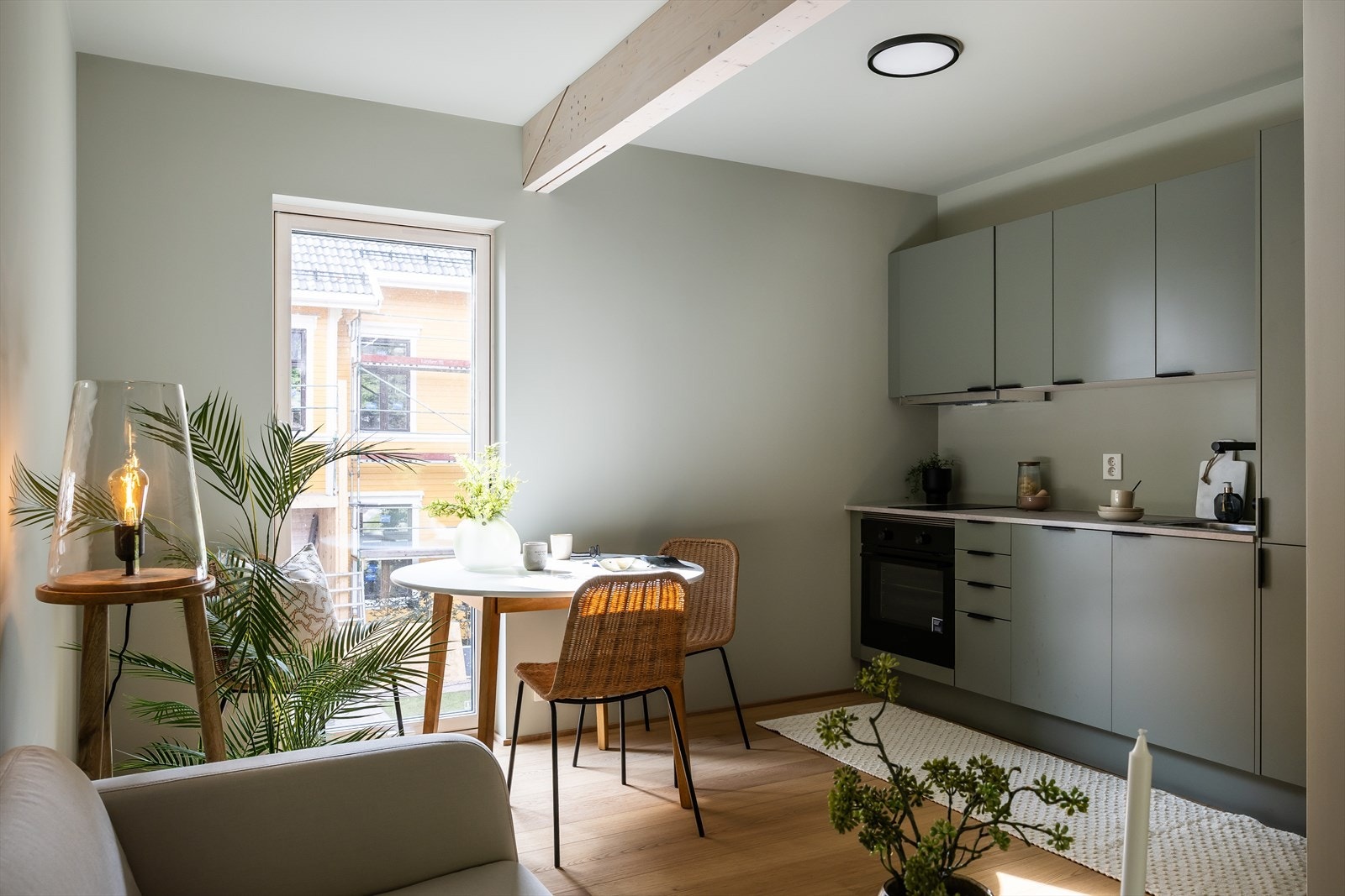 Praktikantdel - Stue og kjøkken i en åpen løsning med plass til sofa og liten spisegruppe. Praktikantleiligheten er effektivt utnyttet med god romfordeling. Galleribilde