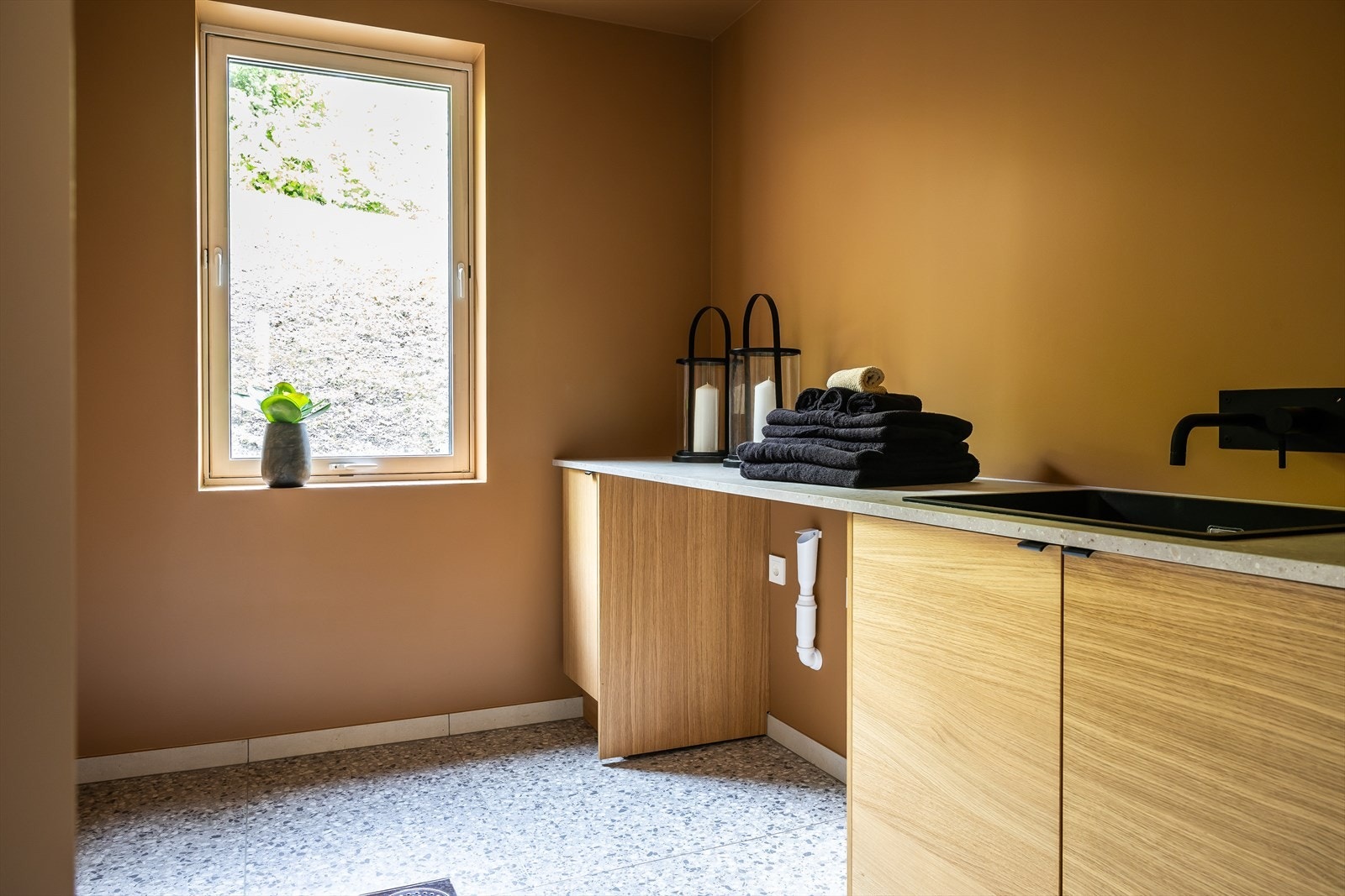 Praktisk vaskerom med hyllesystem, servant og opplegg for vaskemaskin og tørketrommel Galleribilde