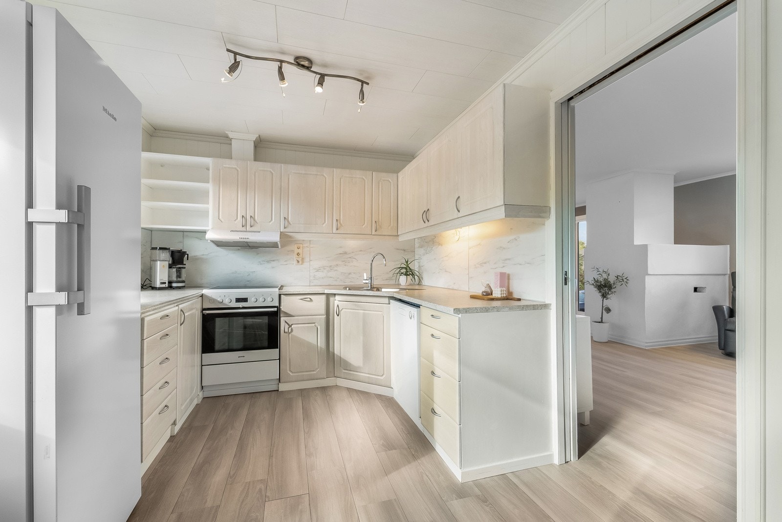 Pent kjøkken med lys profilert innredning og avsatt plass til hvitevarer som medfølger handelen. Galleribilde