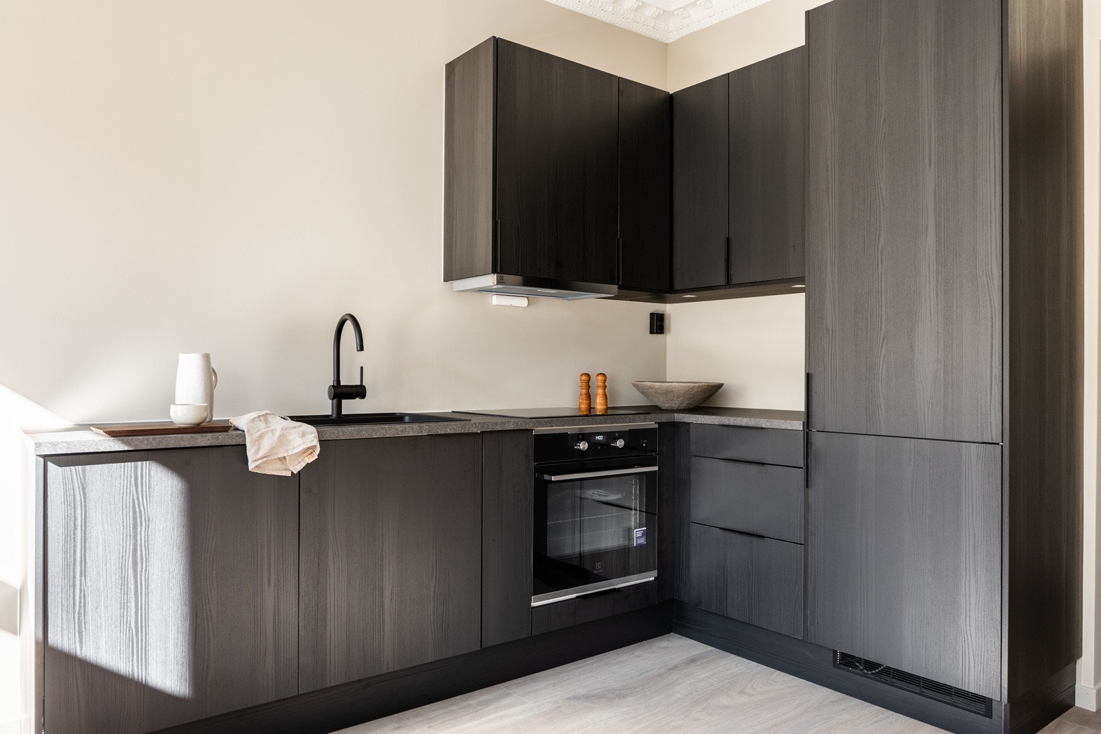 Kullfiltervifter over integrert koketopp/ovn og integrert kjøleskap med frysdel og oppvaskmaskin. Galleribilde