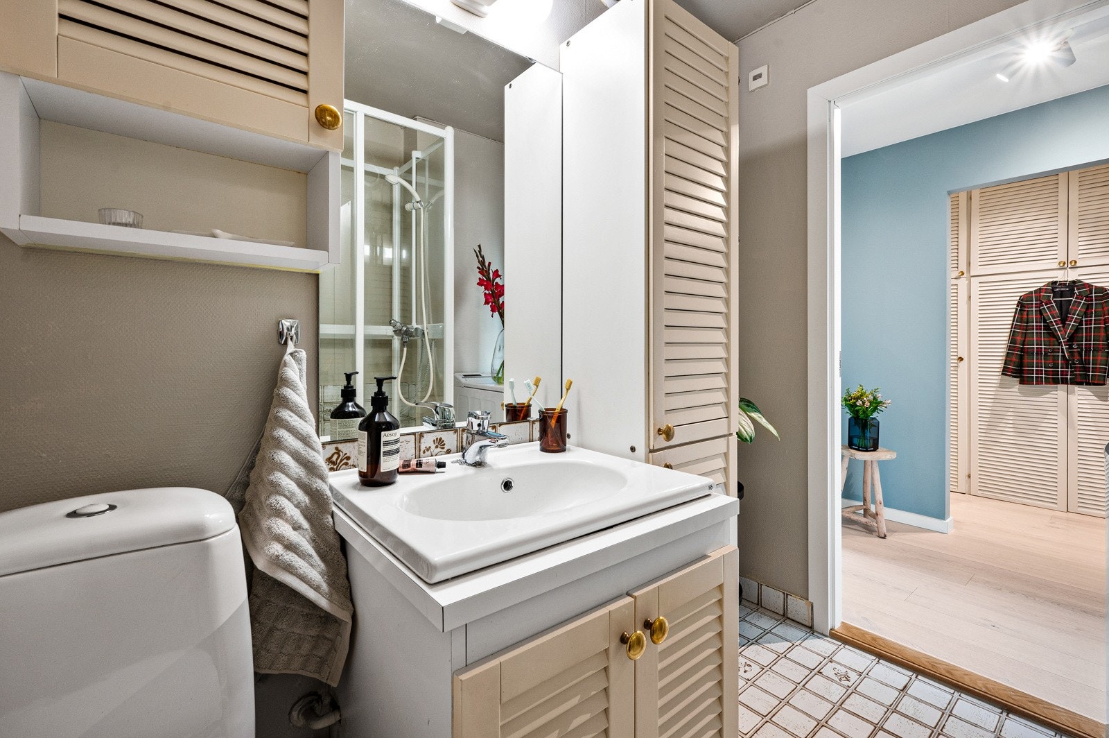 Badet består av toalett, dusjkabinett i herdet glass og baderomsinnredning med malte fronter og laminat benkeplate med nedfelt servant. Galleribilde