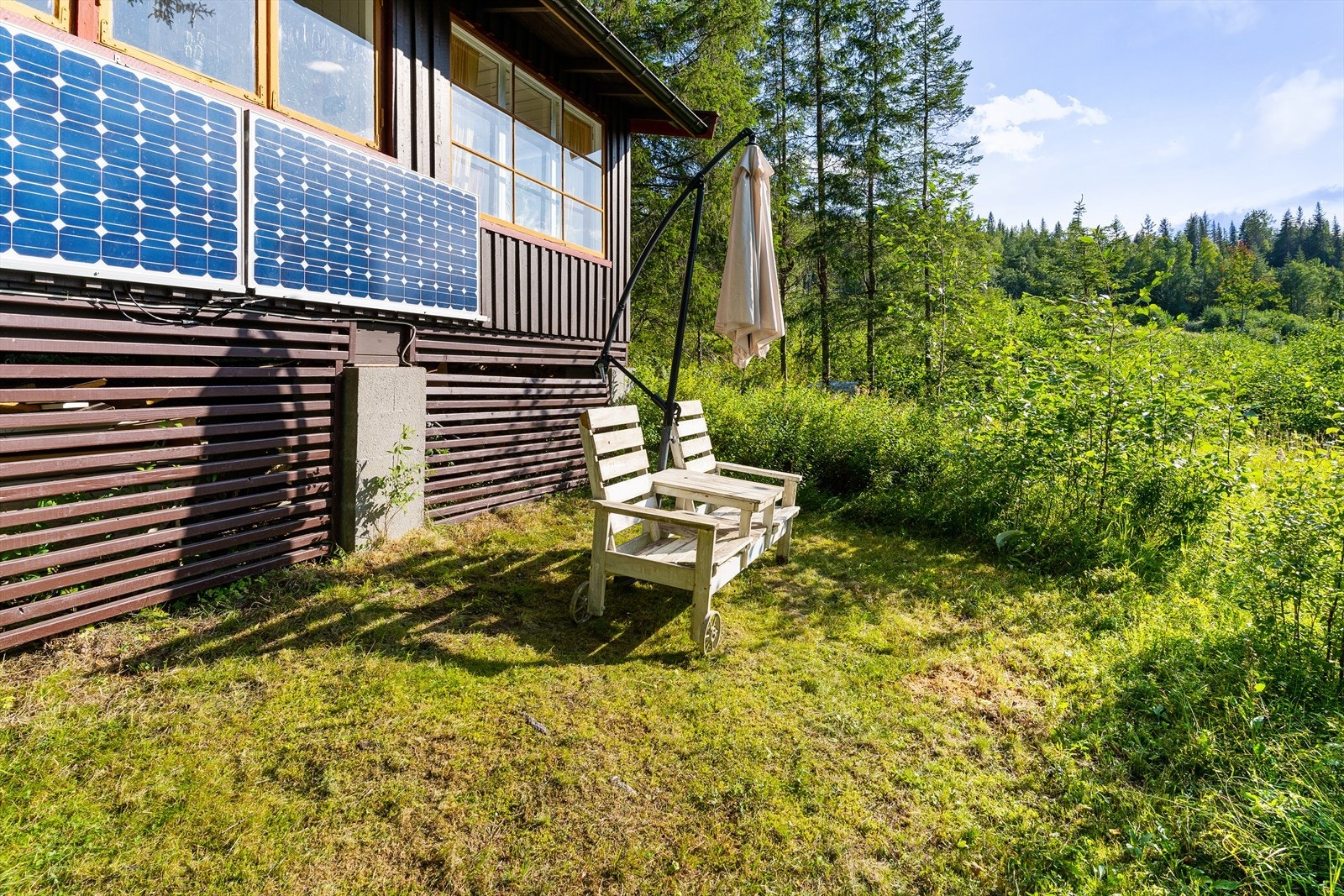 Naturtomt med uteplass og utsikt ned på Haugsjø. Galleribilde