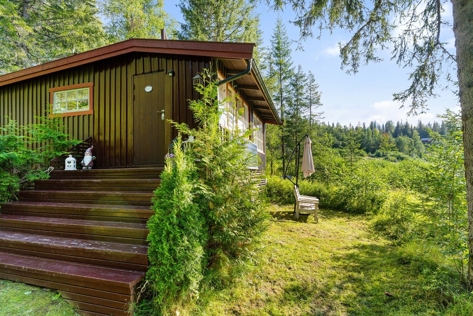 Hytta ligger i et skrånet terreng og naturlig omgivelser. Galleribilde