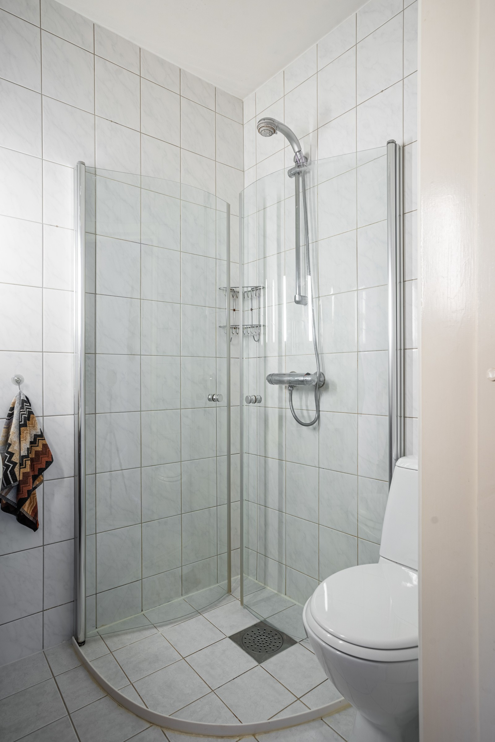 Flislagt bad med dusjhjørne og wc.