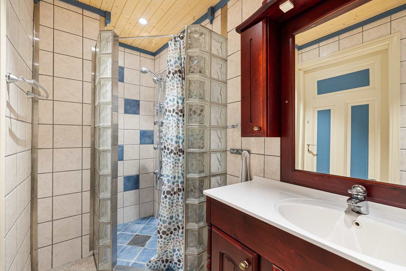 Innredet med stort servantskap, vegghengt wc og dusjhjørne med glassbyggerstein. Galleribilde