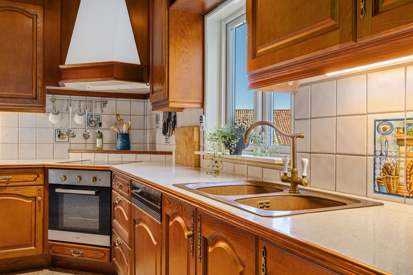 Benkeplaten er av laminat med fliser på vegg over benker. Det er er plass for kjøleskap og integrerte hvitevarer som oppvaskmaskin, platetopp og stekeovn. Galleribilde