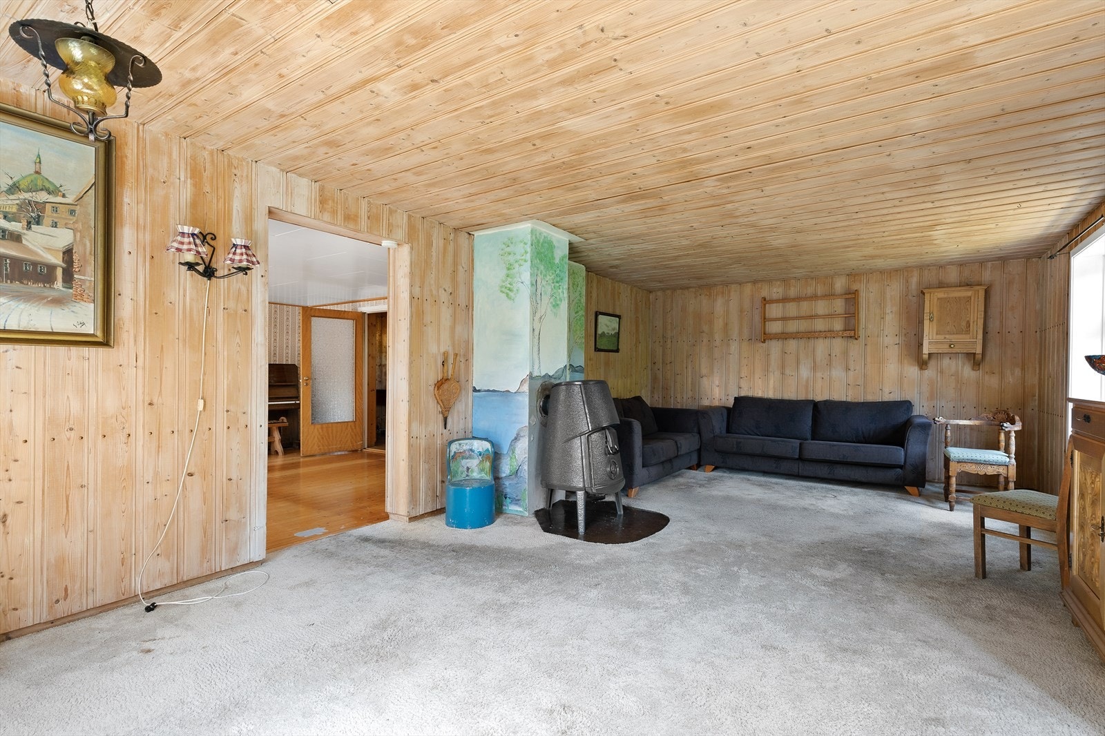 Hovedstuen med god plass til større sofagruppe og TV-krok. Det er peisovn i rommet som varmer god på kalde dager. Galleribilde