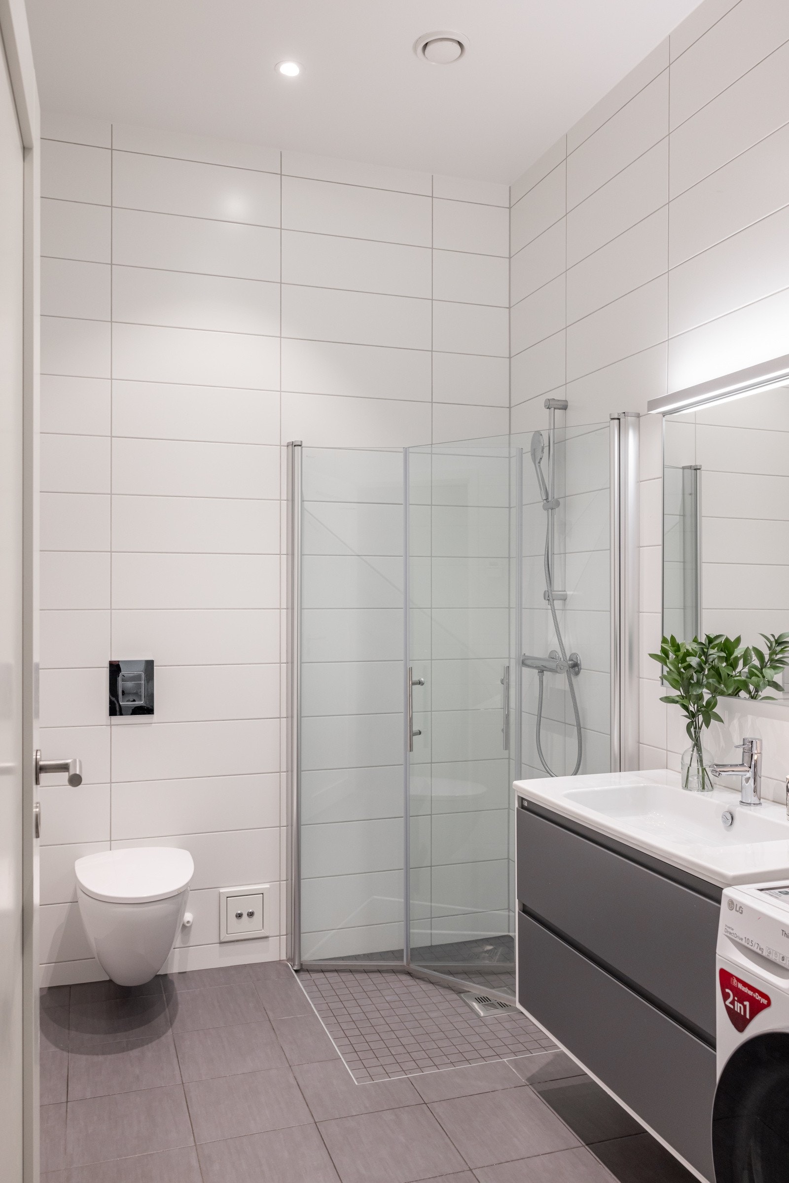 Badet er utstyrt med dusjhjørne med innfellbare dusjvegger og vegghengt toalett. Galleribilde