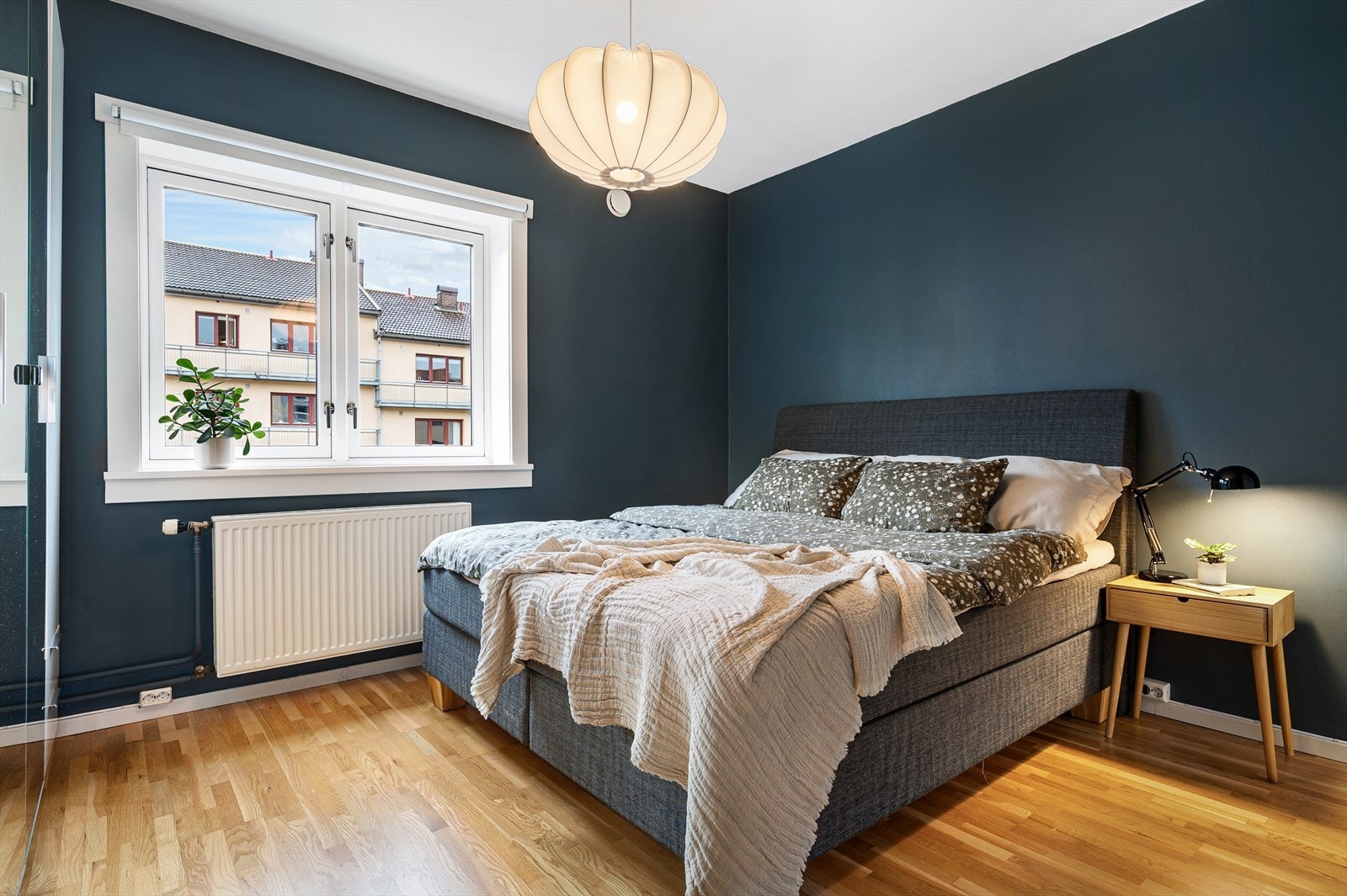 Et romslig soverom med plass til stor dobbeltseng og tilhørende nattbord på begge sider. Galleribilde