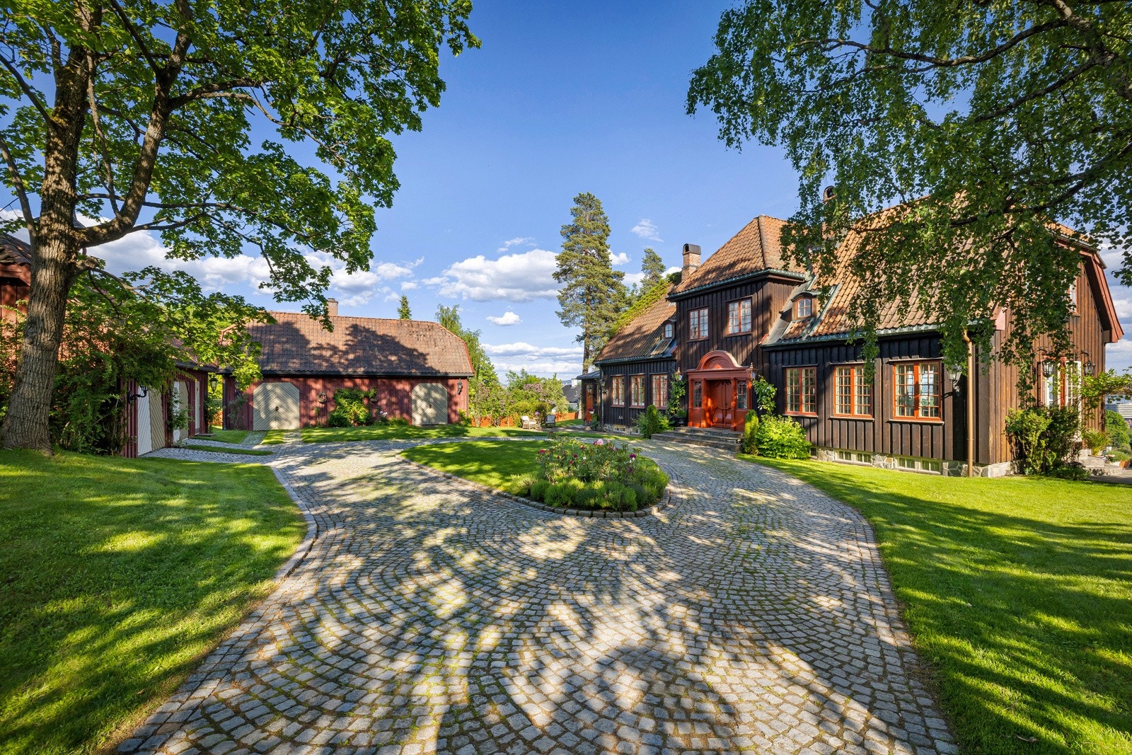 Meget gjennomført gårdsplass med bl.a. brostensbelagt innkjøring/rundkjøring/parkering. Garasjen på tunet har plass til 2 biler, samt god lagringsplass på loftet. Galleribilde
