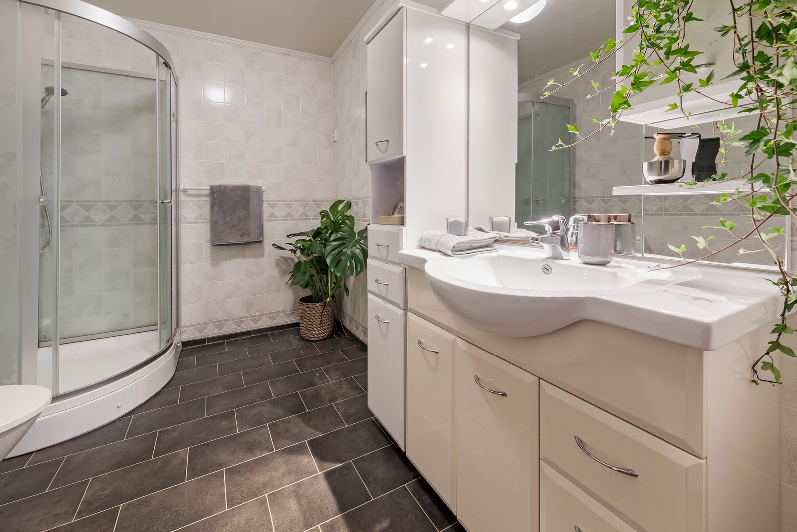 Badet har varme i gulv, innredning med nedfelt servant, gulvstående toalett og dusjkabinett Galleribilde