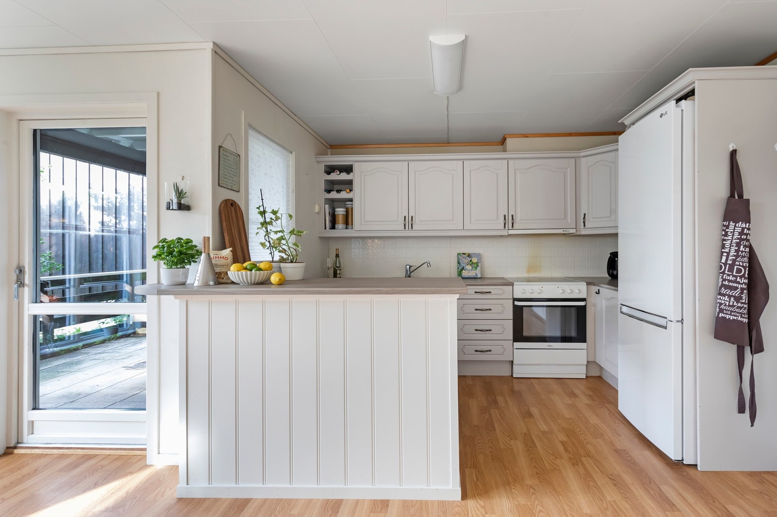 Kjøkkenet er fra byggeår og innredningen har profilerte fronter og laminert benkeplate Galleribilde