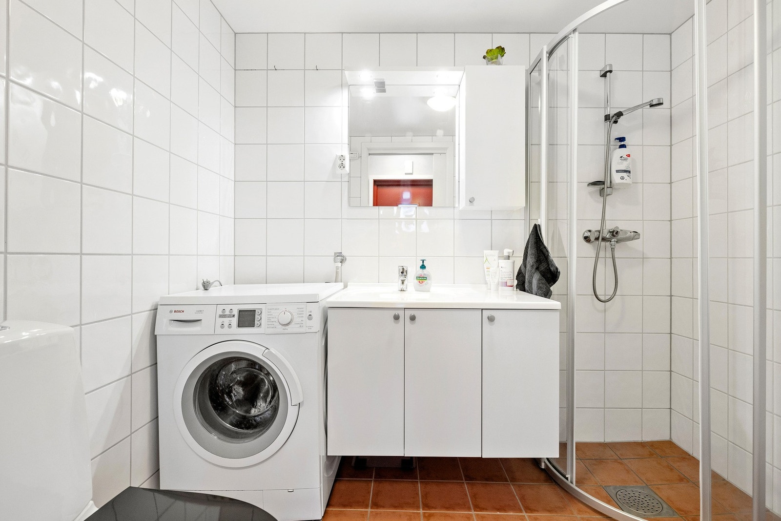 Flislagt baderom med opplegg for vaskemaskin. Galleribilde